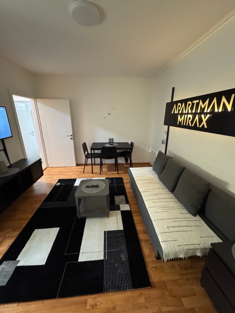 MIRAX living room with a sofa, coffee table and dining table, looking towards the door