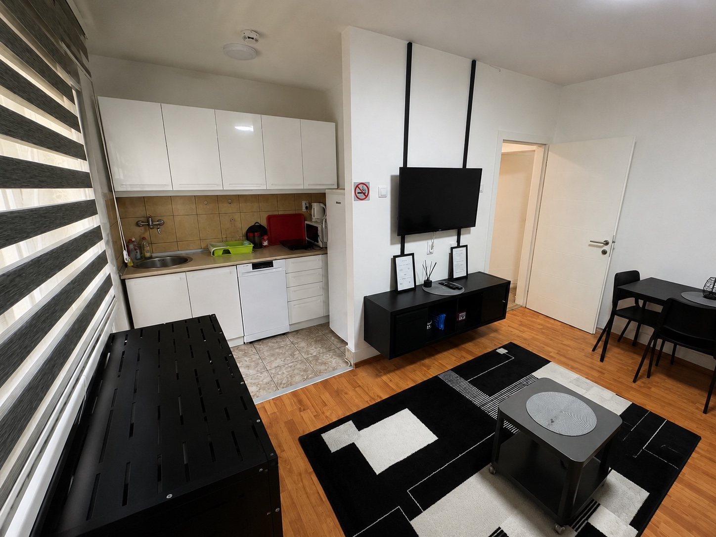 Bela kuhinja sa sudoperom, frižiderom i uređajima u apartmanu MIRAX u Kraljevu