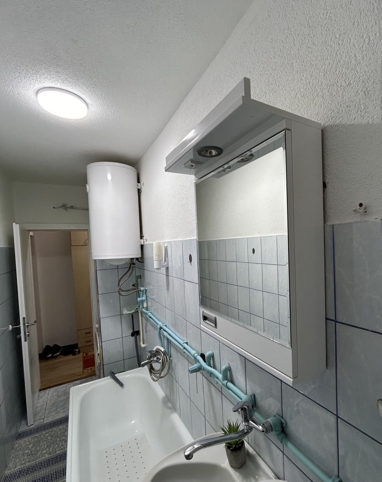 Kupatilo apartmana MIRAX sa kadom, lavaboom, ogledalom i bojlerom