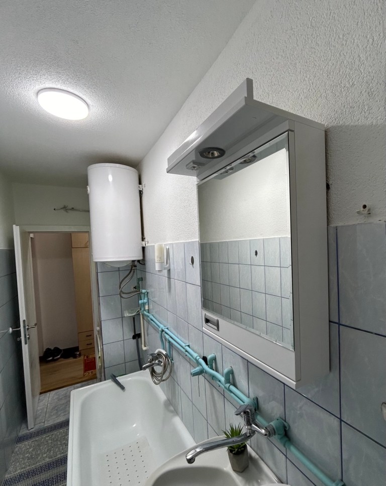 MIRAX bathroom with a bathtub, basin, mirror and water heater