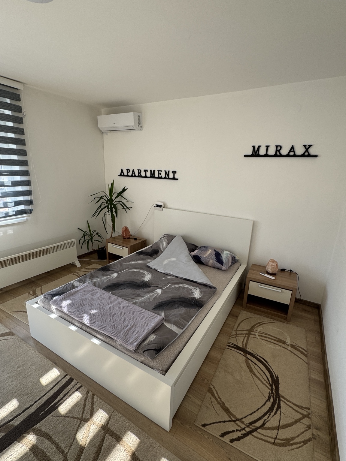 Bračni krevet, noćni ormarići i klima uređaj u spavaćoj sobi apartmana MIRAX