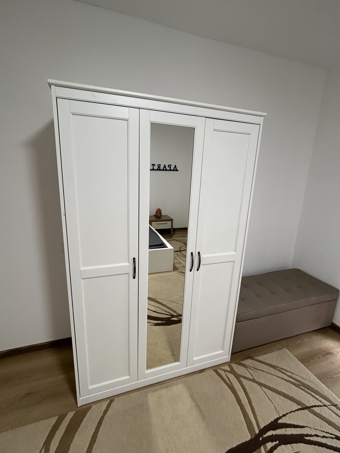 Beli garderober sa ogledalom i tapacirana klupa u spavaćoj sobi apartmana MIRAX